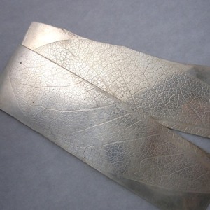Leaf roll-printed on silver.
