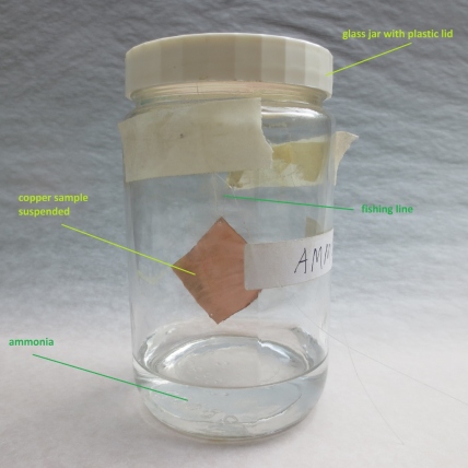 OPTION A: The metal is suspended in a glass jar by a fishing line, without touching the liquid. The jar is tightly sealed.